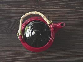 bule chinês vermelho em uma mesa de madeira foto