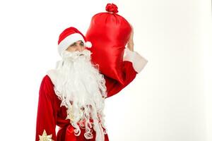 santa claus em pé acima em branco fundo com dele saco cheio do presentes foto