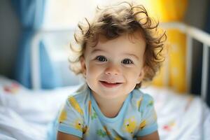 retrato do sorridente encaracolado bebê dentro dele cama foto