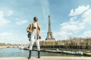 França, Paris, sorridente mulher em pé em uma ponte com a eiffel torre dentro a fundo foto