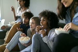 amigos sentado em sofá assistindo televisão foto