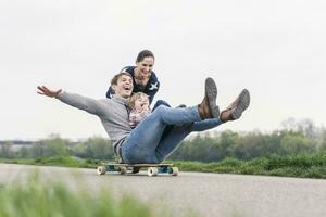 pai e filho tendo diversão, jogando com skate ao ar livre foto