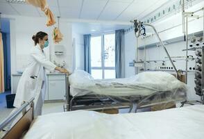 médico dentro hospital quarto empurrando camas foto
