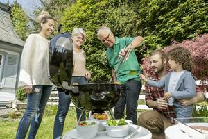 estendido família tendo uma churrasco dentro jardim foto