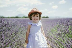 França, Provença, valensole platô, feliz criança pequena menina dentro roxa lavanda Campos dentro a verão foto