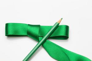 lápis de cor enrolados em uma fita verde foto
