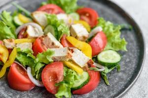 deliciosa salada fresca com frango, tomate, pepino, cebola e verduras com azeite de oliva foto