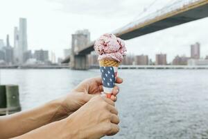 EUA, Novo Iorque cidade, brooklyn, fechar-se do mulher às a beira-mar segurando a gelo creme cone foto