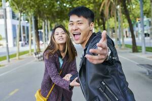 feliz casal convidativo alguém para Junte-se eles para uma andar, barcelona, Espanha foto