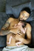 pai deitado em sofá com nu recém-nascido bebê foto