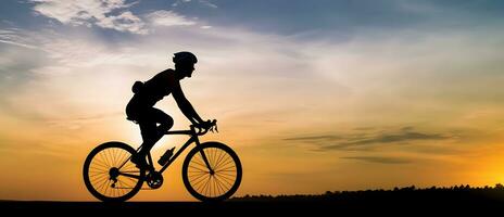 silhueta do saudável homem equitação bicicleta em a estrada às pôr do sol foto