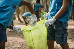 fechar-se do voluntariado crianças colecionar lixo dentro uma parque foto