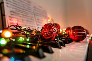 piano chaves decorado com decoração luzes e vermelho bola, fechar acima foto
