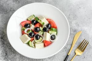 deliciosa salada grega fresca com tomate, pepino, cebola e azeitonas com azeite de oliva foto