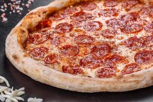 pizza de calabresa com molho de pizza, queijo mussarela e calabresa foto