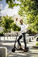 jovem afro-americano usando scooter elétrico em uma rua foto