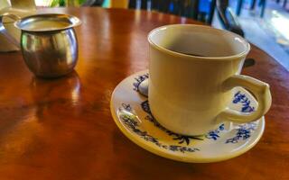 pote de xícara branca azul com mesa de madeira de café preto méxico. foto