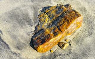 amarelo laranja vermelho pedra Rocha em a de praia areia dentro México. foto