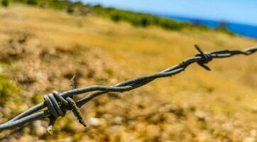 natureza de praia e deserto atrás farpado fio cerca e correntes. foto