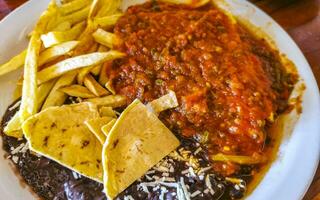 omelete mexicana ovos feijão preto batatas nachos na chapa branca. foto