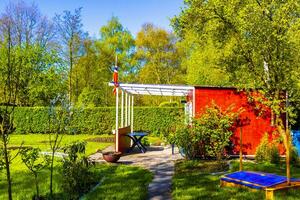 jardim verde com casa de jardim vermelha em estilo norueguês alemanha. foto