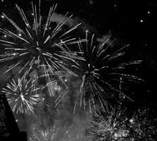 estouro de fogos de artifício coloridos no céu escuro da noite foto