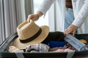 mulher embalagem mala de viagem em cama para uma Novo viagem embalagem Lista para viagem planejamento preparando período de férias livro agora viajando transporte foto