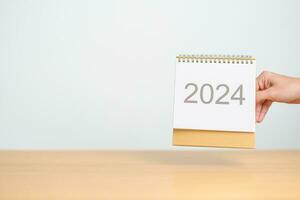2024 ano calendário em mesa fundo. feliz Novo ano, resolução, metas, plano, Ação, missão e financeiro conceito foto