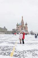 uma linda jovem caminha ao longo da praça vermelha em Moscou durante uma nevasca e nevasca foto