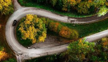 estrada em zigue-zague, emoldurada por uma floresta laranja de outono foto