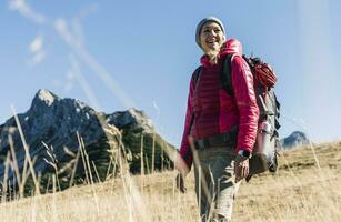 Áustria, Tirol, feliz mulher em uma caminhada viagem dentro a montanhas foto