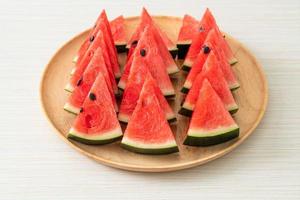 melancia fresca cortada em prato de madeira foto