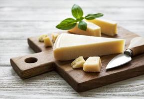 pedaço de queijo parmesão em uma placa de madeira foto