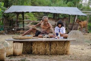 homem idoso e artesanato de bambu com a aluna foto