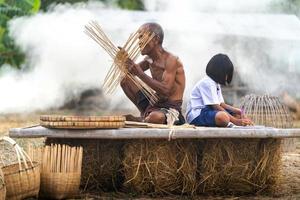 homem idoso e artesanato de bambu com a aluna foto