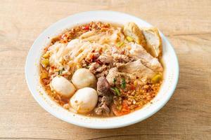 macarrão com carne de porco e almôndegas em sopa apimentada ou macarrão tom yum em estilo asiático foto