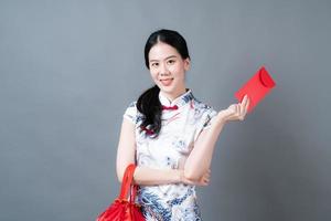 mulher asiática usa vestido tradicional chinês com envelope vermelho ou pacote vermelho foto