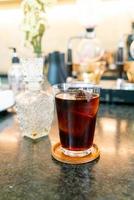 café frio ou café preto americano em vidro com cubo de gelo em cafeteria e restaurante foto