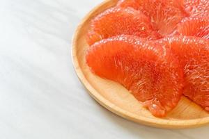 pomelo vermelho fresco ou toranja no prato foto