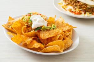 chips de tortilla de nachos mexicanos com jalapeño, guacamole, molho de tomate e molho foto