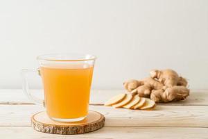 copo de suco de gengibre fresco e quente com raízes de gengibre - estilo de bebida saudável foto