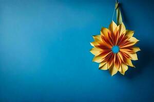 uma amarelo e laranja origami flor suspensão em uma azul muro. gerado por IA foto