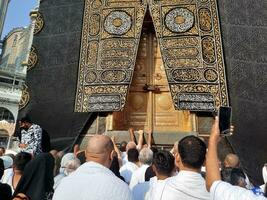 meca, saudita Arábia, agosto 2023 - peregrinos a partir de todos sobre a mundo reunir perto a porta do a kaaba dentro masjid al haram. foto