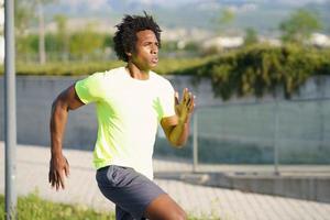 homem negro atlético correndo em um parque urbano.