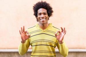 homem negro com cabelo afro com uma expressão engraçada foto