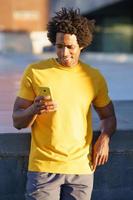 homem negro consultando seu smartphone enquanto descansava do treino.
