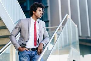 empresário negro com cabelo afro em pé ao ar livre. foto