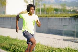 homem negro atlético correndo em um parque urbano. foto