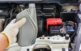 mão de mecânico de automóveis segurando óleo do motor, manutenção do carro foto