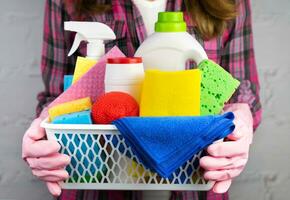 uma jovem mulher dentro borracha luvas detém limpadores e detergentes para limpeza a casa. fechar-se. seletivo foco. foto